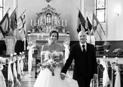 fotografische begleitung einer romantischen kirchlichen trauung im saarland, das strahlende brautpaar verlässt die kirche, fotografiert von karin trinh